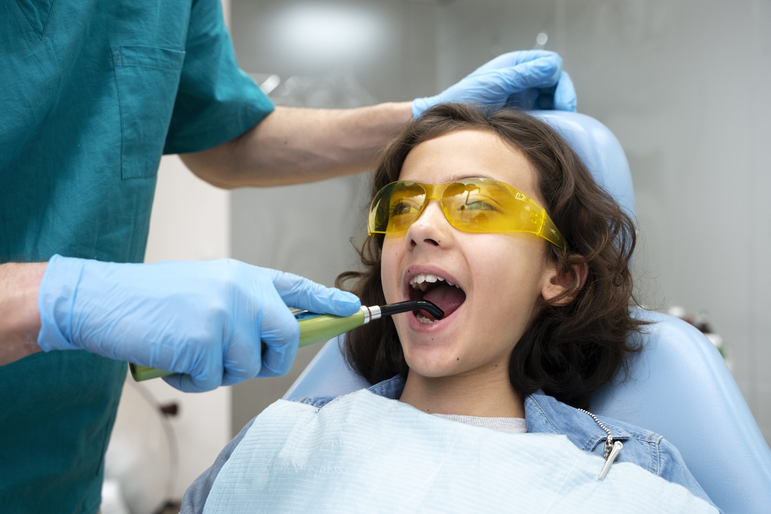 a little girl is getting dental treatment